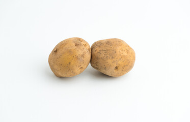 Fototapeta premium Two fresh raw brown baby potatoes isolated on a clean white background