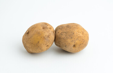 Fototapeta premium Two fresh raw brown baby potatoes isolated on a clean white background