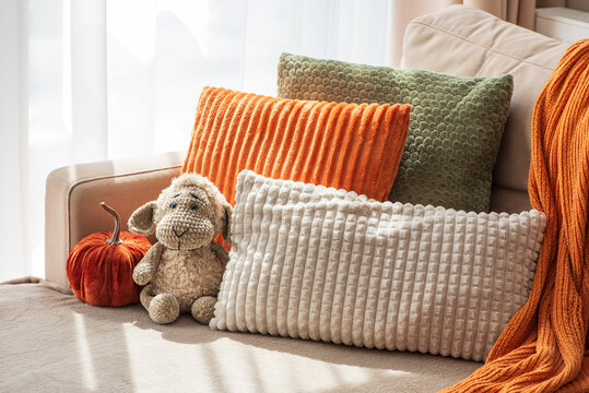 Cozy Sofa Scene With Plush Pillows Decorative Pumpkin And Sheep Toy For Autumnal Home Decor