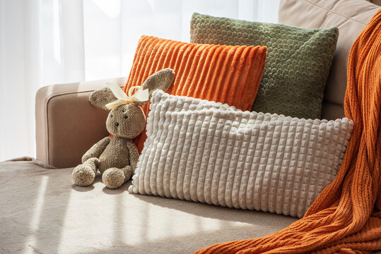 Cozy Autumn Living Room Scene With Plush Cushions And A Stuffed Rabbit