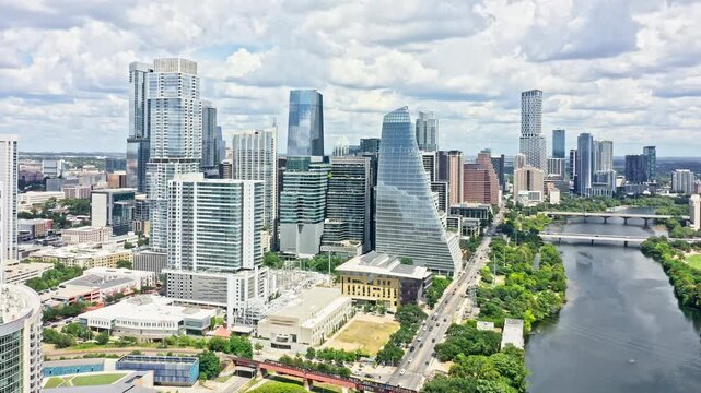 Aerial revealing shot of Austin, Texas skyline with slow camera pull back, along Colorado river. Austin is the capital city of the U.S. state of Texas.