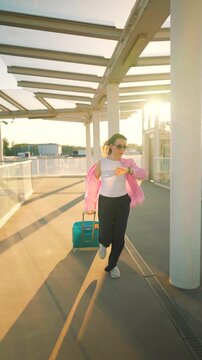 Caucasian woman pulling a suitcase and running, late for flight. Slow motion