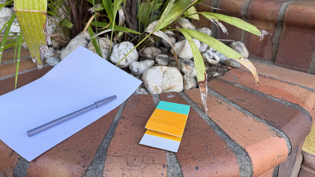Stationery items including paper, a marker, and adhesive tabs on an outdoor surface