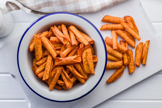 Spicy Corn Snack Chips in White Bowl on Cutting Board, Seasoned Crispy Finger Food