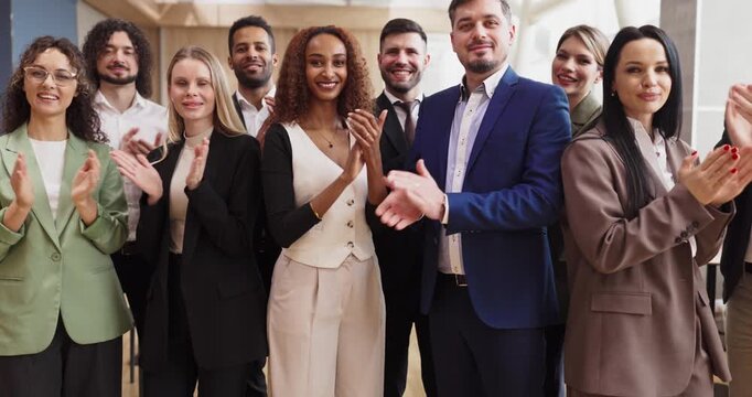 Business team people group applause celebration success. Diverse colleagues in suits clap after a workplace milestone honoring recognition and achievement. Clear concept of teamwork success.