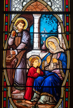 Stained glass (19th century) of Holy family: Jesus infant, Virgin Mary and St Joseph in the workshop of Joseph the carpenter.