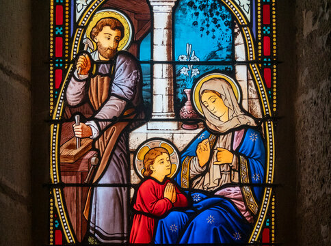Stained glass (19th century) of Holy family: Jesus infant, Virgin Mary and St Joseph in the workshop of Joseph the carpenter.
