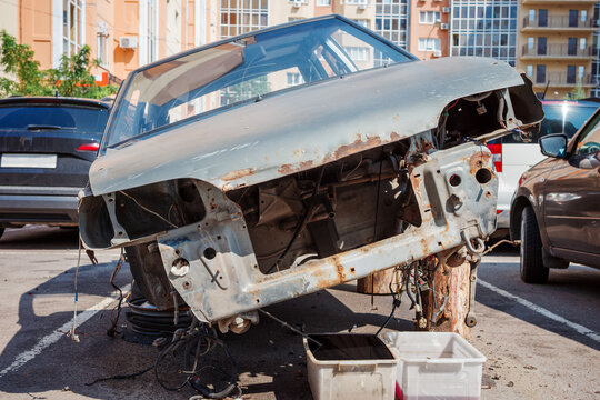 Stripped vehicle front with missing engine parts, automotive dismantling, salvage and recycling.