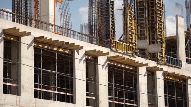 Modern construction site with reinforced concrete structure and formwork elements, showing the process of high-rise building development and urban growth