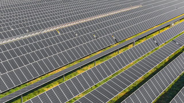 Aerial view of photovoltaic panels mounted on single-axis solar trackers at a large utility-scale solar power plant in Le Pouzin, Auvergne-Rhone-Alpes, France.