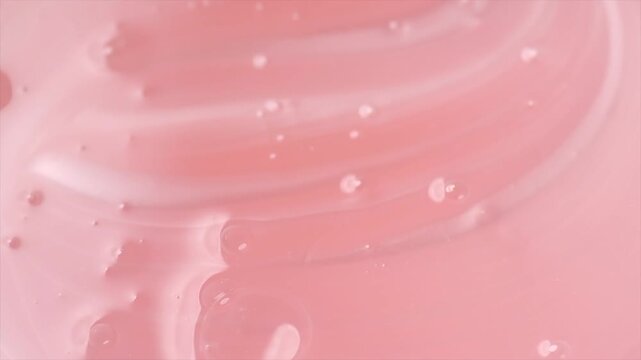 Pearlescent pink liquid soap, shower gel swirl texture, surface of liquid fluid, background, shampoo texture, body care cosmetic, texture of liquid washing gel, soap backdrop top view, rotating. 