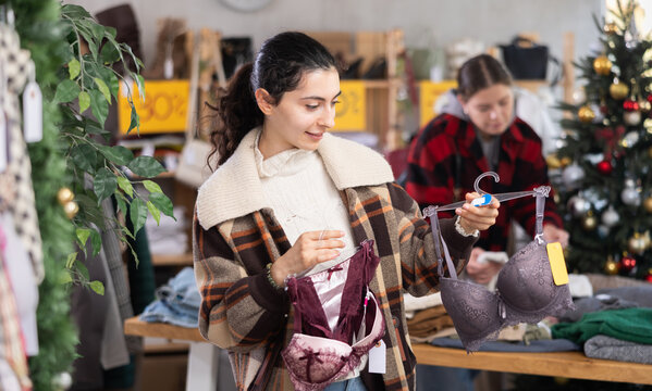 Seasonal trade sale, client at X mas holiday shopping time. Asian woman search and choose brassier, pick up some wardrobe items. Modern urban casual fashion