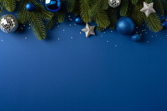 Blue Christmas ornaments and fir branches on blue background for Merry Christmas and Happy New Year
