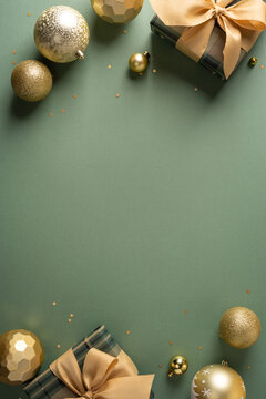 Golden Christmas ornaments and wrapped gifts on sage vertical green background for Merry Christmas and Happy New Year