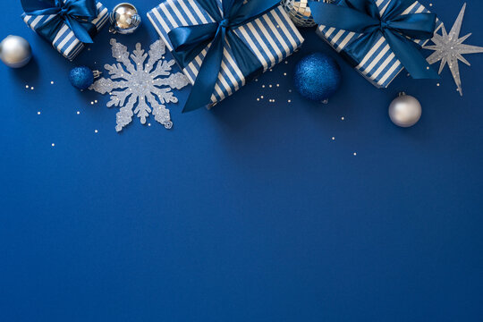 Blue Christmas gift flatlay with striped presents, ribbon bows, ornaments and festive New Year decorations