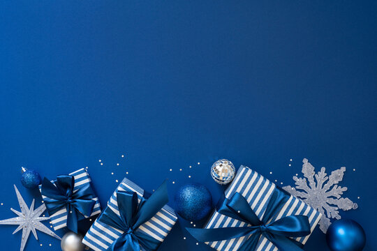 Blue Christmas present with satin ribbon, ornaments and silver snowflake for Merry Christmas Happy New Year