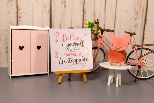 Believe in Yourself and Be Unstoppable Motivational Quote on Romantic Pink Decor.
