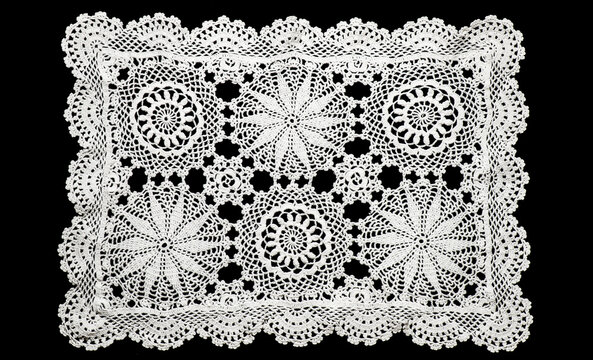 Crochet lace patterns, crocheted Grandmas Doily, Detail of hand-crocheted napkin isolated on black background border art design. Craft, vintage linen. Hobby concept, flat lay 