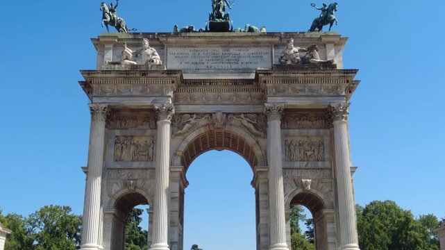 Monumental arch of peace, arco della pace, in milan, a neoclassical triumphal arch and iconic city gate located at the edge of sempione park, with sforza castle visible in the background