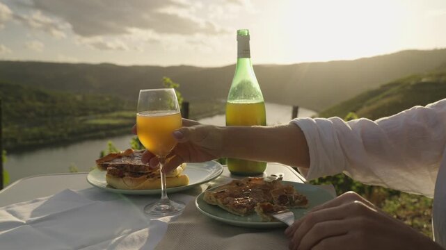Young Woman Enjoys Federweisser young wine served with Onion tart Zwiebelkuchen. Rhine Valley terraced vineyards Germany