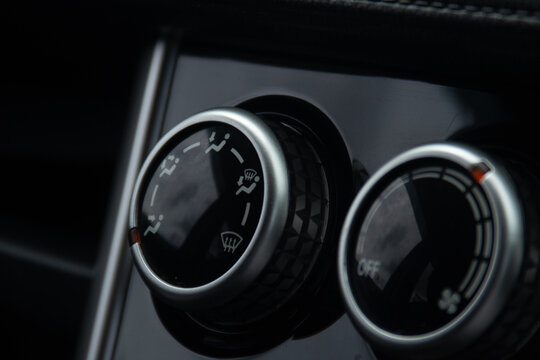 Car interior climate control air conditioning ventilation dashboard control knob close up automotive cabin heater controls with defrost and airflow icons, modern vehicle dashboard detail with dark