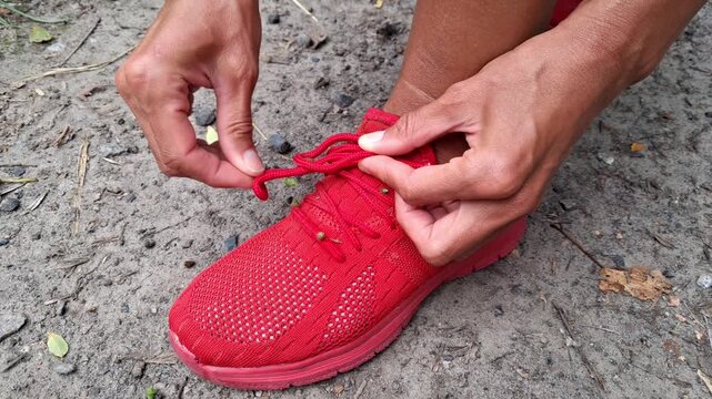 A young woman is cleaning dry seeds off her sneakers.Sharp dry seed pods of The Podmarennik Tenacious adhered to clothing.