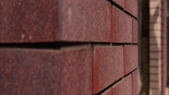 Textured red brick facade corner under construction close up