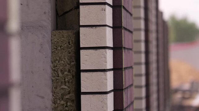 Brick facade with exposed insulation layer under construction close up
