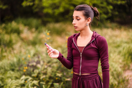 Young woman vaping electronic cigarette outdoors