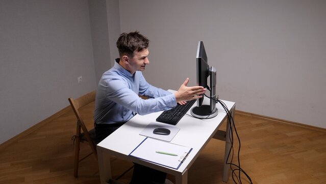 Angry businessman expressing frustration and shouting at a computer screen during a video call or experiencing a technical malfunction, feeling overwhelmed by work pressure