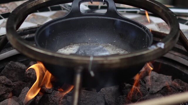 Scooping Molten Lead From Cast Iron Pot Over Open Flame
