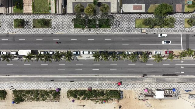 Drone top-down view of Copacabana coastal road with traffic and palm trees, Rio de Janeiro