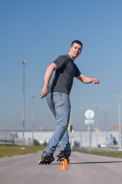 A Caucasian man rollerblades around the slalom course.