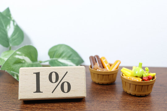 食料品の消費税率1%減税。おもちゃの食材とバスケット。木製ブロック表示