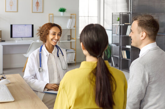Couple and doctor consultation on pregnancy planning. Fertility healthcare appointment as a physician guides discussion of options and next steps. Clear concept of supportive family care.
