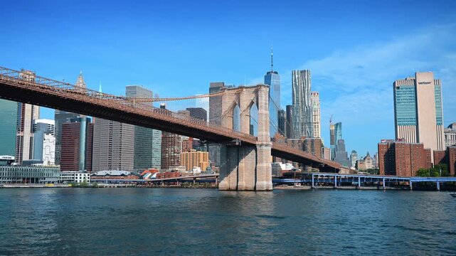 New York, USA, 4 Jule 2026 : Brooklyn Bridge and Lower Manhattan skyline. Stone towers and suspension cables span the East River beneath a clear blue sky.
