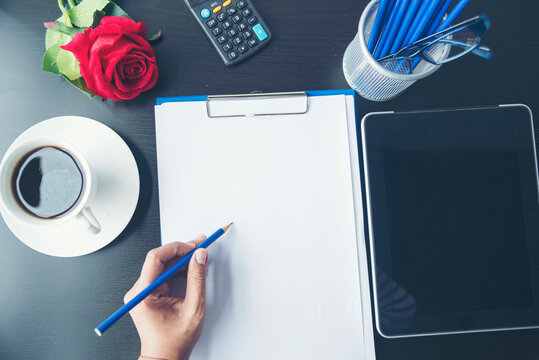 Woman freelance reading business graphs sale report on business office desk. Woman working at home office desk using laptop business financial document chart and graph on wooden table with coffee cup