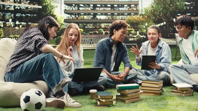 Woman student discusses project notes with classmates near an open laptop on a university campus bench, supporting peer tutoring, collaborative group study, academic teamwork and project work.