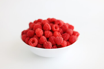 A close‑up of a red raspberry on a white background. © Мария Чепрасова