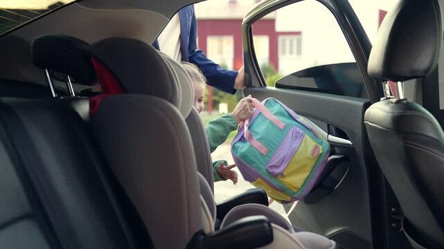 child seat car. father man puts girl daughter child seat car. happy family. schoolboy child seat. happy child car seat. childhood trip with dad. road traffic. road safety rules. girl with school