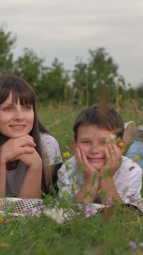 man woman relax hugging child outdoors, group people picnic in park, child kid son boy mother father smiling hugging outdoors, young people together vacation fun dream, happy family, man woman child