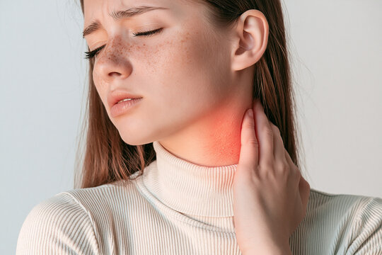 Young Woman Touching Sore Throat with Glowing Red Spot Indicating Neck Pain or Thyroid Inflammation