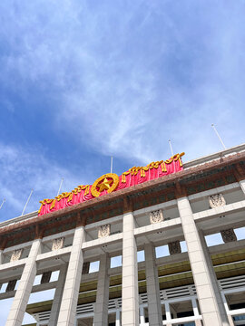 View of the National Museum of China featuring its iconic red banners and gold star emblem atop the grand columns under a clear blue sky in Beijing, Beijing, China.
