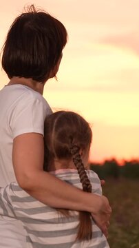 mother woman parent female, child girl kid childhood outdoors, Mother and daughter watching sunset, Family love and bonding, Peaceful evening embrace, Parent and child outdoors, Warm hug at sunset