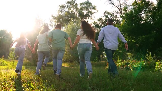 Mother father child kid run towards sunset park, happy family, running dad mom girl boy son daughter, group people run holding hands, hand in hand toward the light, family adventure on a summer field