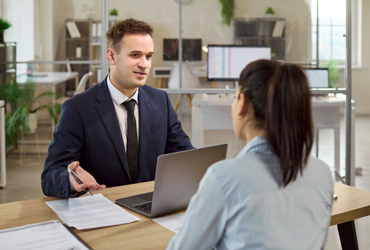 Advisor and client in loan consultation meeting. Clear talk on terms and approval at a modern office desk. Concept banking advice and loan help.
