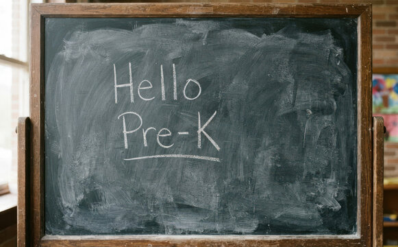 Chalkboard with Hello Pre-K written on it in a classroom, representing preschool education and the first day of school for young children learning fundamentals.