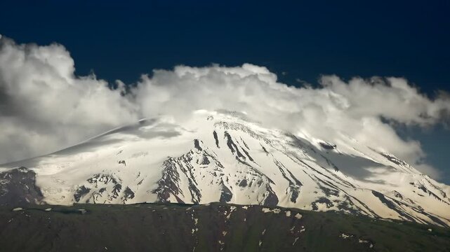 Mount Kilimanjaro Tanzania snowy summit rises through swirling clouds and alpine sky.