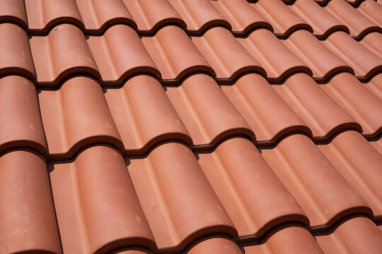 New terracotta clay roof tiles closeup texture pattern background on residential building