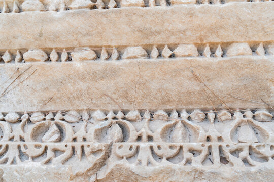 Closeup of ancient Roman marble relief carving with floral acanthus leaf decoration at archaeological site